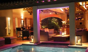 Magnificent stream-of-water fountain on the edge of a swimming pool with lighting effects