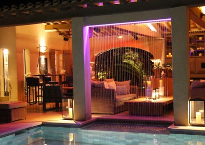 Magnifique fontaine fil d'eau au bord d'une piscine avec des effets lumineux